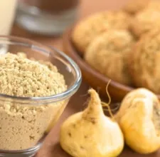 Whole maca roots beside a glass bowl of maca powder, a stock photo from the brand's image set
